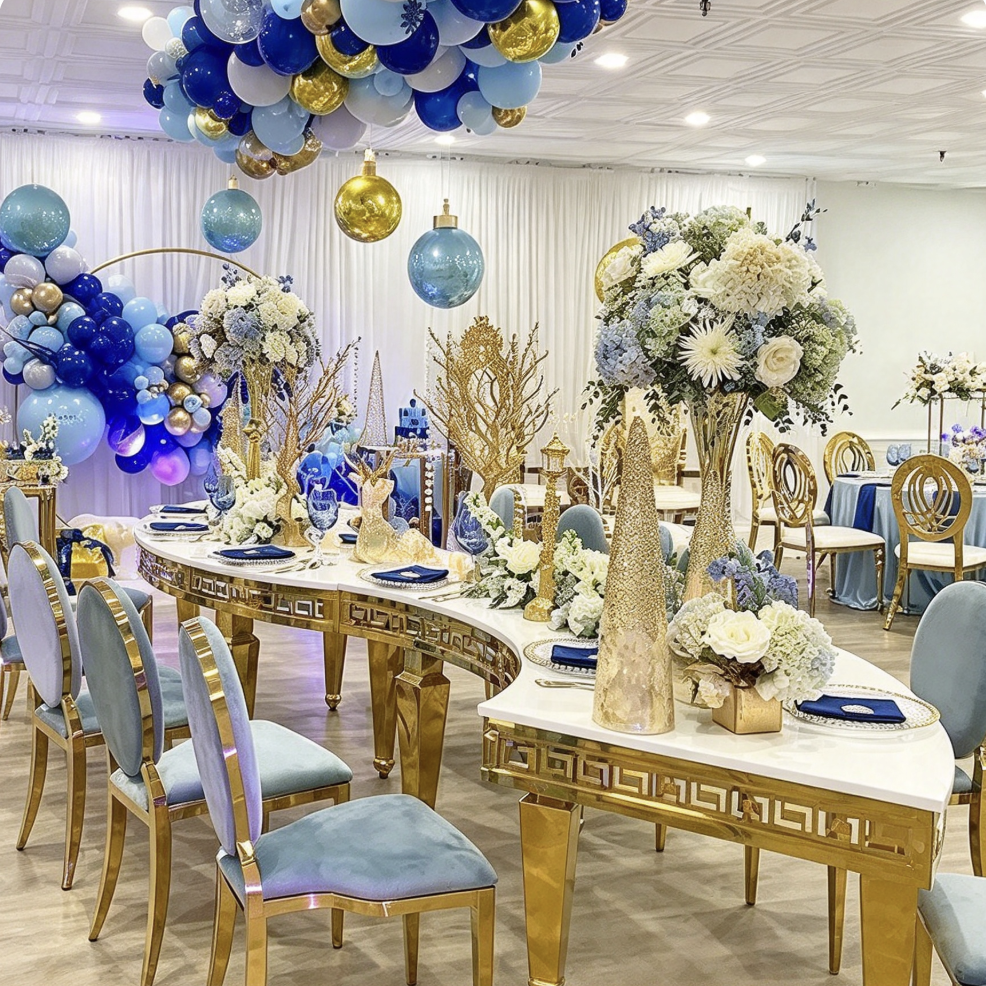 White curved table with gold geometric legs and banquet chairs
